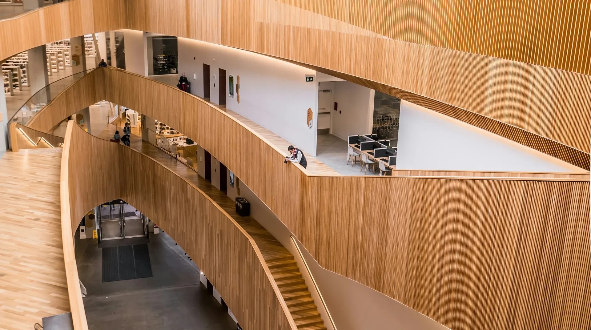 Een vide met houten balustrades, over meerdere verdiepingen
