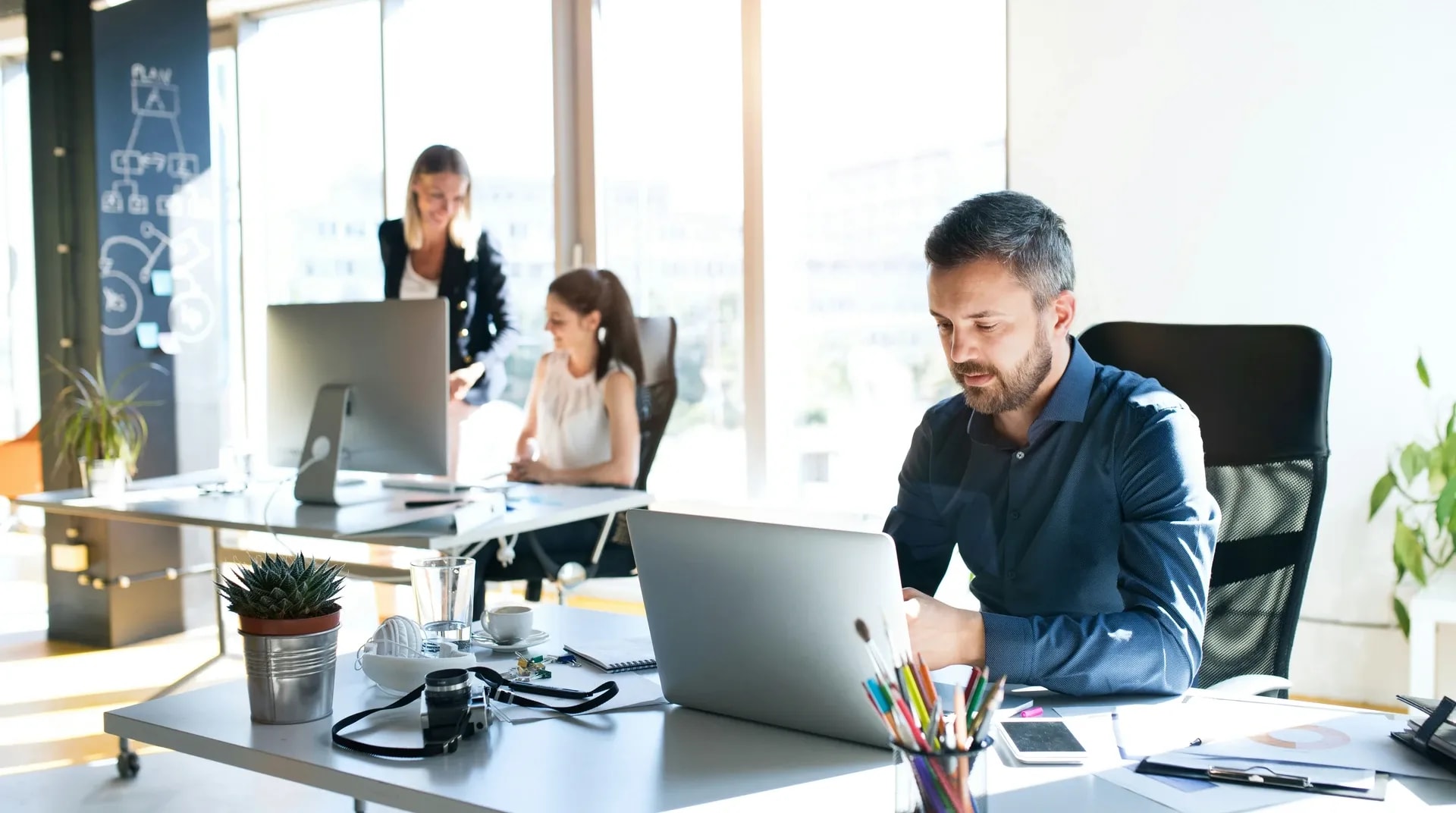 Collega’s aan het werk aan bureaus bij het raam