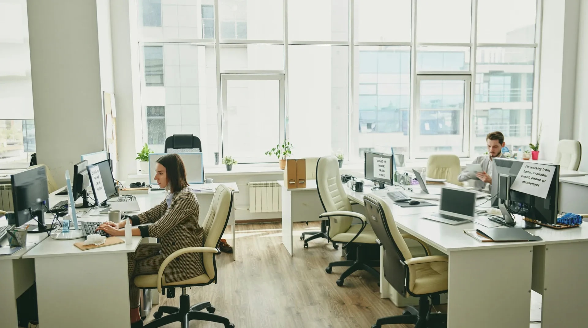 Kantoorvloer met vrije werkplekken en een enkele collega aan het werk